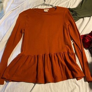 Rust colored long sleeve peplum type top